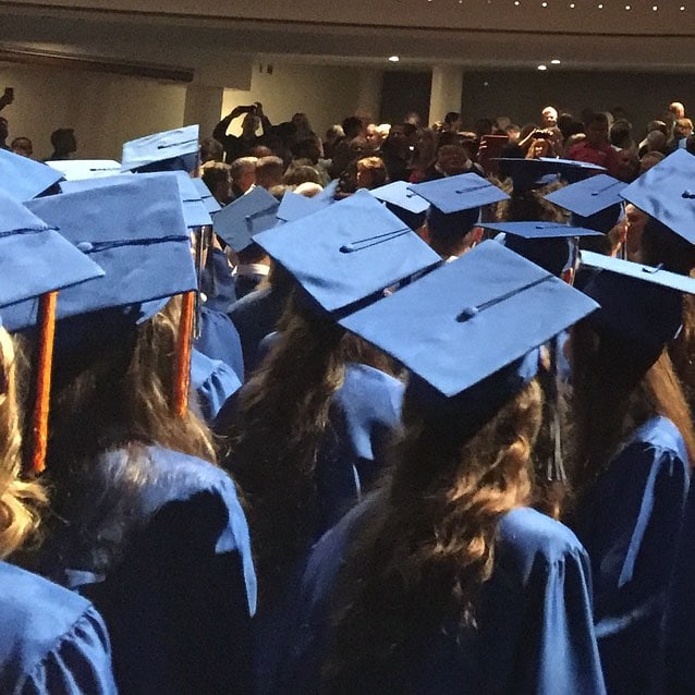 Graduation ceremony with blue caps and gowns